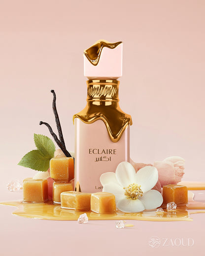 lattafa eclaire perfume bottle photograph beside creamy caramel and honey at ground with jasmine against pink background