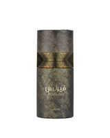 A cylindrical perfume bottle with a textured dark metallic finish, featuring a gold brick-patterned band around the middle and gold Arabic lettering that reads 'FEARLESS' with 'lattafa' below, set against a plain white background.