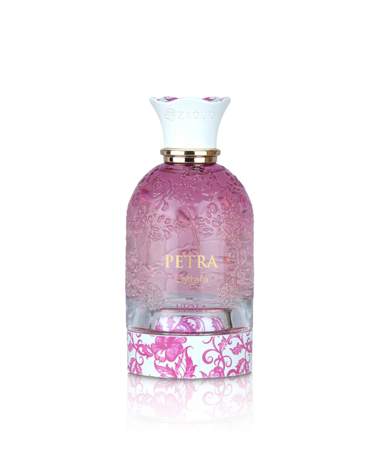 A perfume bottle named lattafa PETRA, featuring a pink frosted glass body with embossed floral patterns, a gold collar, a white neck with pink floral accents, and a pink and white damask patterned base, set against a plain white background with a soft reflection.