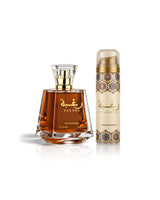 lattafa raghba perfume bottle with amber liquid and a gold cap, shown next to a matching cylindrical deodorant canister with a beige and gold patterned label, on a white background with a soft reflection.