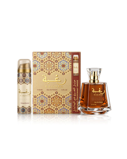 lattafa raghba perfume bottle with amber liquid and a gold cap, a matching cylindrical deodorant spray canister, and a decorative patterned box, all labeled BAGHA on a clean white background.