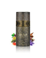 A cylindrical cosmetic bottle labeled 'Fearless' by lattafa, featuring a textured dark gray and gold design with Arabic text. The bottle is centered on a white background with decorative botanical and citrus elements arranged at its base.