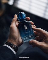 Man holding Laverne Tyrant Eau de Parfum bottle in a dark luxury lifestyle setting, representing a woody aromatic men’s fragrance.