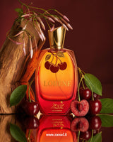 Lorene Eau de Parfum red and orange gradient bottle with cherry design and gold cap styled with fresh cherries and wood