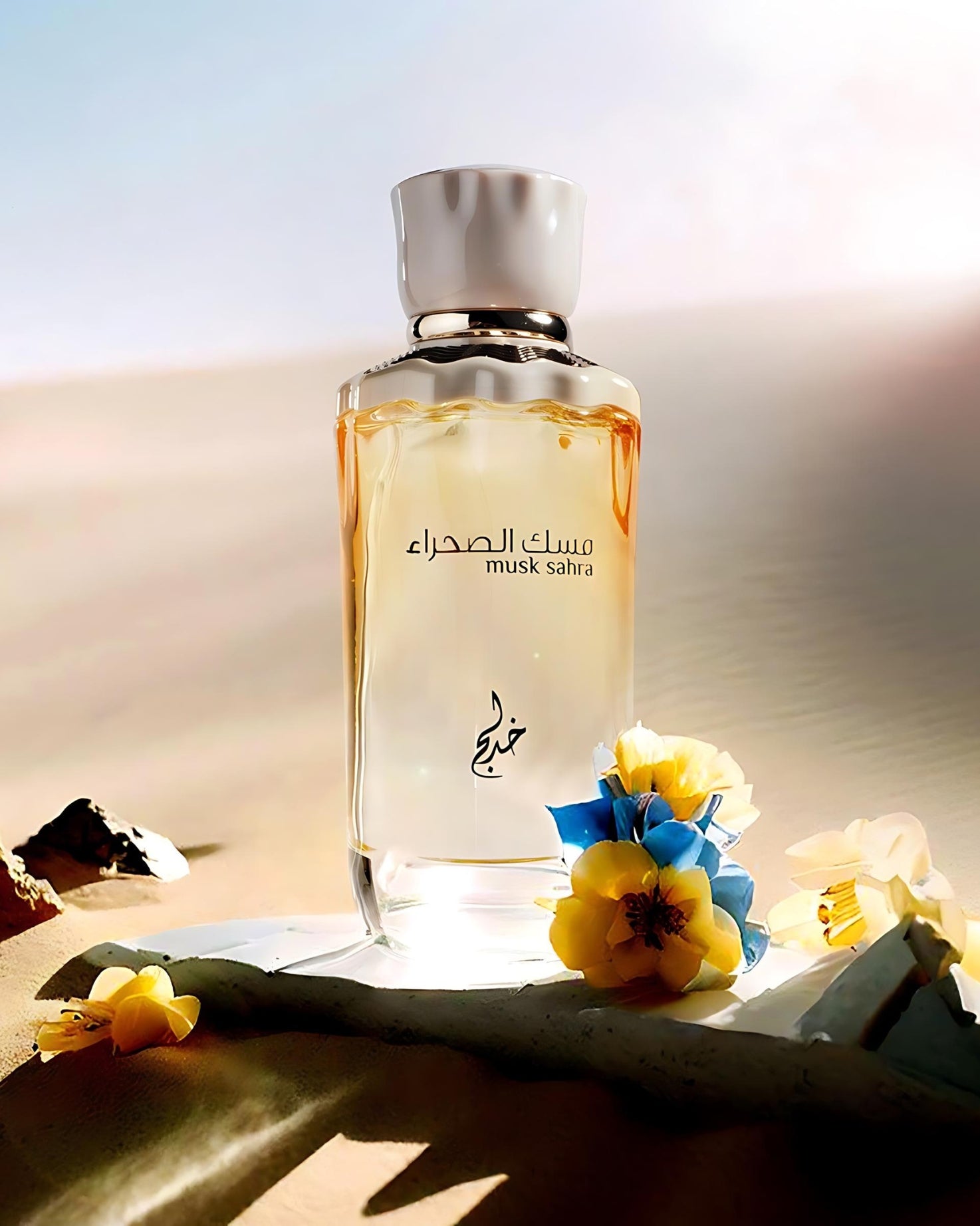 musk sahra edp by khadlaj perfume bottle photograph at desert over a rock piece with besides some fallen flowers