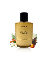 musk safi elixir perfume bottle surrounded by fragrance notes like amber and lilly of the valley shows against white background