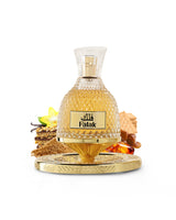 nusuk falak perfume bottle surrounded by fragrance notes like brown sugar and amber shows against white background