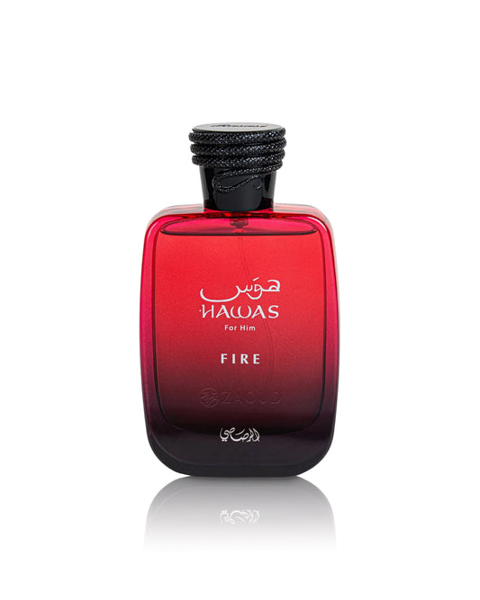 A bottle of hawas Fire For Him cologne, featuring a red gradient glass bottle with a black cap, shown on a white background with a soft reflection.