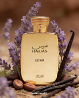 Gold perfume bottle labeled 'Hawas Elixir' surrounded by lavender flowers and vanilla beans on a blurred background.