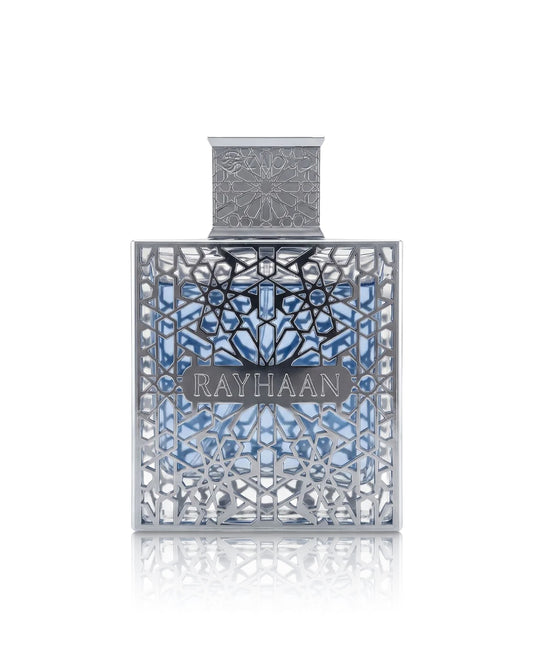 Rayhaan aquatica PERFUME bottle with intricate silver filigree detailing and a blue patterned background, centered on a white reflective surface.