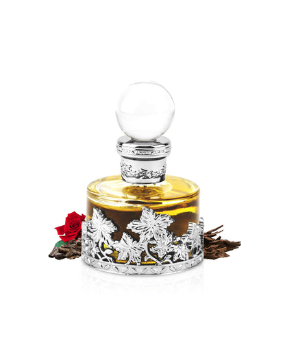 rose malaki perfume oil by wiss arabian bottle surrounded with its ingredients like rose and oud with many others shows from behind the bottle against white background