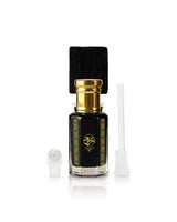A black glass sabbah perfume oil bottle with a gold cap and gold decorative borders, shown with a black cap, a white dropper, and a white applicator on a white background.