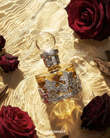Swiss Arabian Rose Malaki perfume oil bottle placed among red roses and water reflections, representing a rich oud rose luxury attar fragrance.