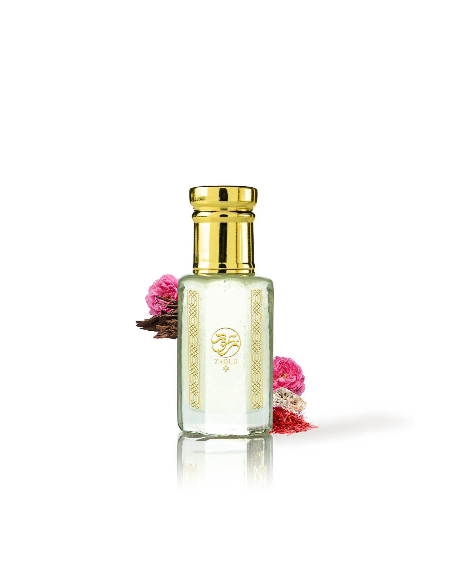 taif sama perfume oil bottle with a shiny gold cap and gold decorative patterns on the front, filled with a pale yellow liquid. The bottle is centered on a white background with a soft reflection below, and small pink flowers are tucked behind it on both sides.