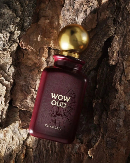 wow oud edp by khadlaj perfume bottle photograph layed over a old wood log with sunlight from left side