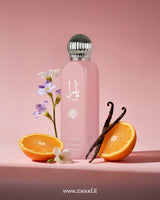 Lattafa Yara All Over Spray, surrounded by orange slices, vanilla sticks, and purple flowers. The background is a soft pink color.